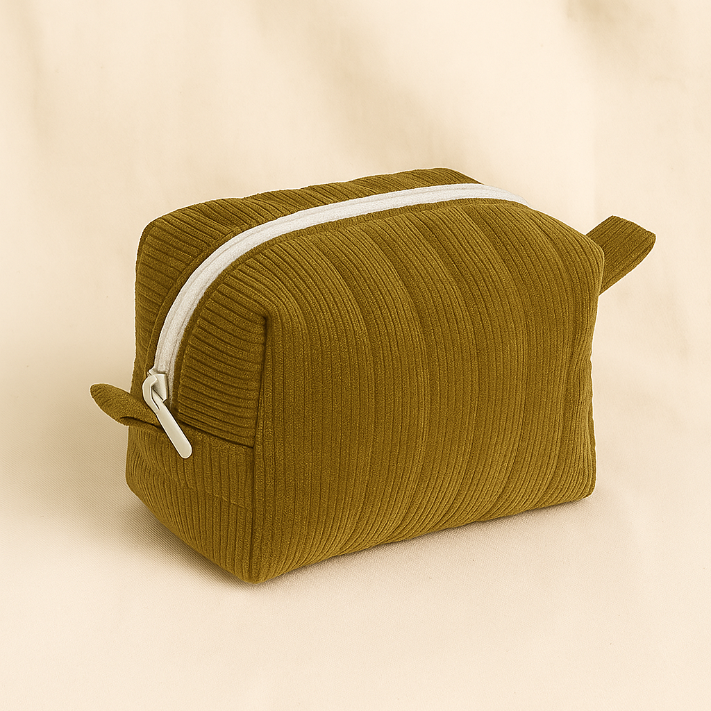 Green textured toiletry bag with a white zipper on a beige background